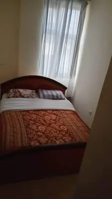 a bed in a room with a window and a bedspread at Go there Inn in Az Zarqa