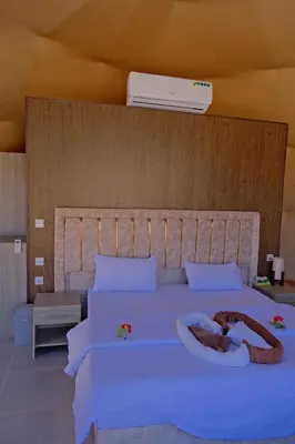 a bedroom with a large white bed with flowers on it at Msek wadi rum camp in Disah