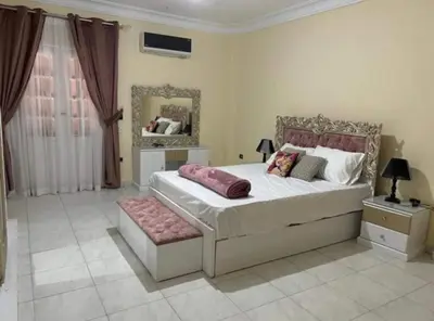 a bedroom with a large bed and a mirror at Lotees House in Udhruḩ