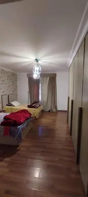 a room with two beds and a chandelier at Lotees House in Udhruḩ
