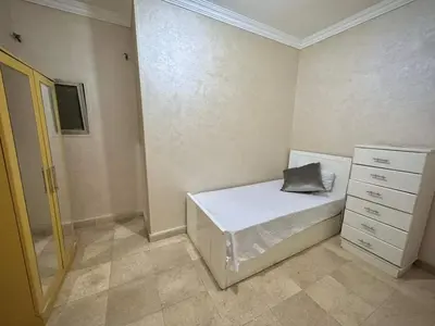 a small bedroom with a bed and a dresser at Lotees House in Udhruḩ