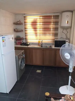 a kitchen with a refrigerator and a washing machine at شقة الراحة و الهدوء economic comfortable flat in Amman