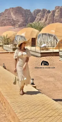 a woman in a white dress walking down a street at ROYAL MOON BUBBLES lUXURY CAMP in Wadi Rum