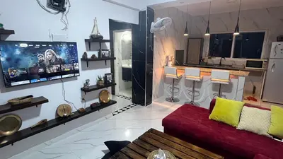 a living room with a couch and a flat screen tv at Bait Al-Masri in Um Qeis