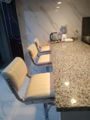 a row of chairs sitting at a counter in a kitchen at Bait Al-Masri in Um Qeis