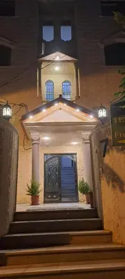 a house with a blue door and stairs at night at زهرة المدائن in Jerash