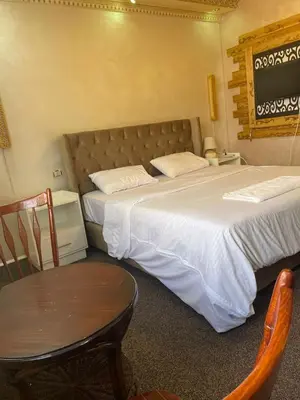 a bedroom with two beds and a table and a chair at زهرة المدائن in Jerash