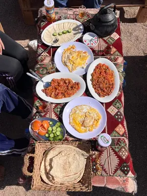 a table with many plates of food on it at Um sabatah camp in Wadi Rum