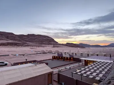 a view of a desert with tents and a parking lot at Ram Al-Umda Luxury Camp in Wadi Rum
