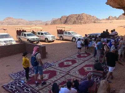 a group of people standing around in the desert at Ram Al-Umda Luxury Camp in Wadi Rum