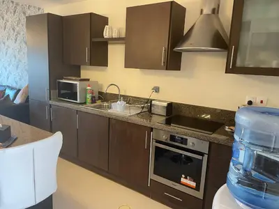 a kitchen with a sink and a stove top oven at The F52 Luxury Residence Samarah Resort in Sowayma