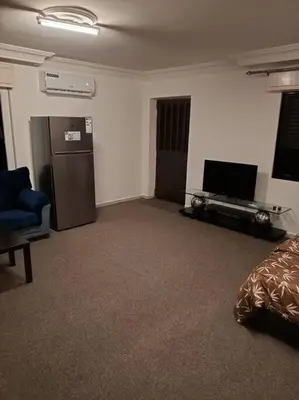 a living room with a television and a refrigerator at Kamalia Studio in Şāfūţ