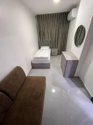 a small room with two beds and a mirror at شقارى 16 in Ţāb Kirā‘