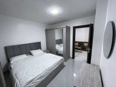 a bedroom with a large bed and a mirror at شقارى 16 in Ţāb Kirā‘
