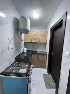 a kitchen with a stove top oven in a room at شقارى 8 in Ţāb Kirā‘