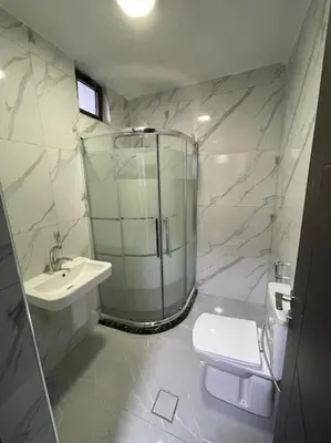a bathroom with a shower and a toilet and a sink at شقارى 8 in Ţāb Kirā‘