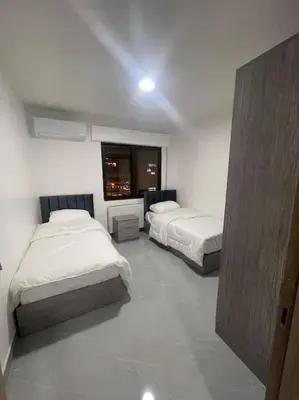 a bedroom with two beds and a window at شقارى 8 in Ţāb Kirā‘