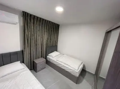 a small bedroom with two beds and a window at شقارى 8 in Ţāb Kirā‘