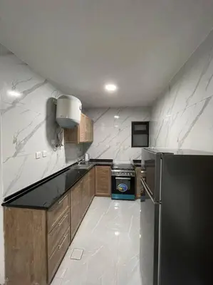 a kitchen with a black and white counter top at شقارى 13 in Ţāb Kirā‘