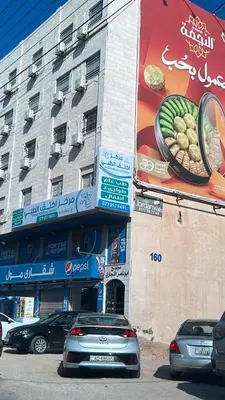 a building with cars parked in front of it at شقارى 13 in Ţāb Kirā‘