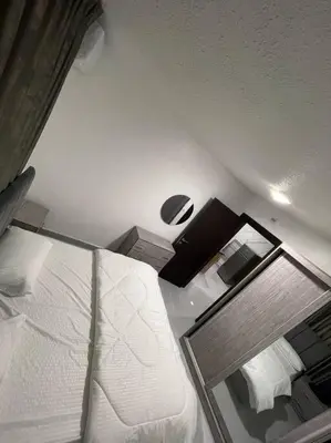 a bedroom with a white bed and a mirror at شقارى 13 in Ţāb Kirā‘