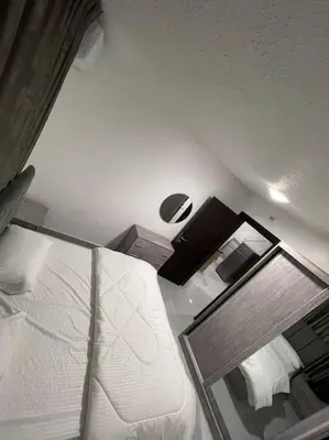 a bedroom with a white bed and a mirror at شقارى 5 in Ţāb Kirā‘