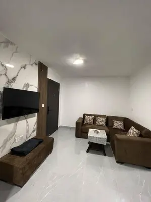 a living room with two couches and a flat screen tv at شقارى 9 in Ţāb Kirā‘