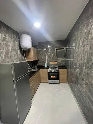 a small kitchen with a refrigerator and a stove at شقارى 9 in Ţāb Kirā‘