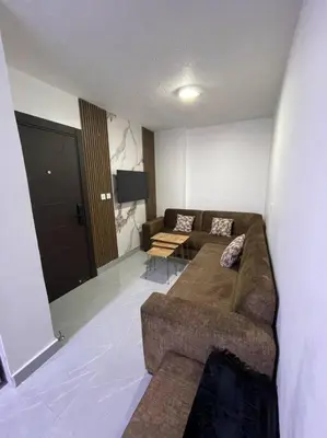 a living room with a couch and a flat screen tv at شقارى 11 in Ţāb Kirā‘