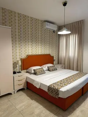 a bedroom with a large bed and a night stand at New Rafi Hotel in Amman