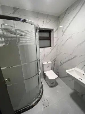 a bathroom with a shower and a toilet and a sink at شقارى 15 in Ţāb Kirā‘