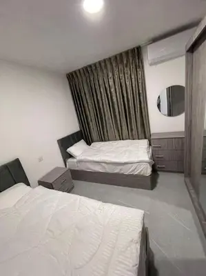 a hotel room with two beds and a window at شقارى 6 in Ţāb Kirā‘