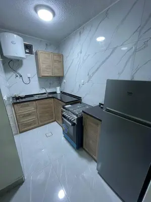 a small kitchen with a stove and a refrigerator at شقارى 7 in Ţāb Kirā‘