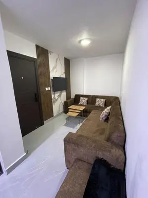a living room with a couch and a flat screen tv at شقارى 10 in Ţāb Kirā‘