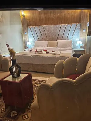 a bedroom with a large bed and a couch at Royal Dunes Camp in Wadi Rum