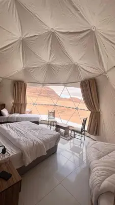 a bedroom with two beds and a large window at RUM MAGIC SANDS BuBBLES CAMP in Wadi Rum