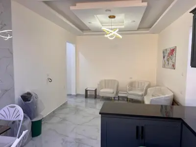 a living room with two chairs and a ceiling fan at شقة مفروشة و جديدة مع كراج للسيارة في ارقى مناطق اربد in Irbid