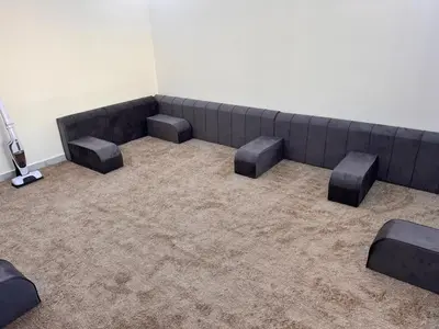 an empty waiting room with a couch and stool at شقة مفروشة و جديدة مع كراج للسيارة في ارقى مناطق اربد in Irbid