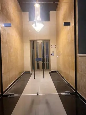 a hallway of a building with two doors and a chandelier at شقة مفروشة و جديدة مع كراج للسيارة في ارقى مناطق اربد in Irbid