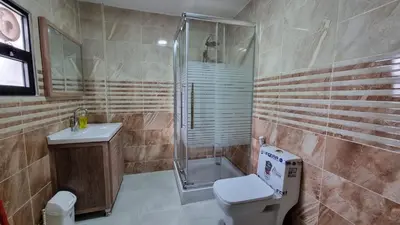 a bathroom with a shower and a toilet and a sink at City centre Apartment in Petra