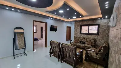 a living room with a couch and a table and chairs at City centre Apartment in Petra
