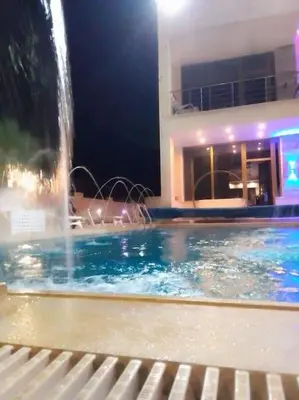 a swimming pool with a fountain in a building at Vienna Villa for you in Al Qasţal