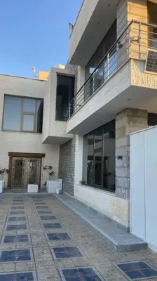 a building with a walkway in front of it at Vienna Villa for you in Al Qasţal
