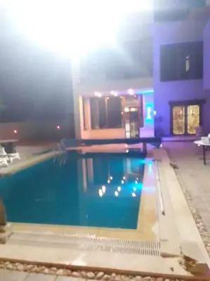 a large swimming pool in a building at Vienna Villa for you in Al Qasţal
