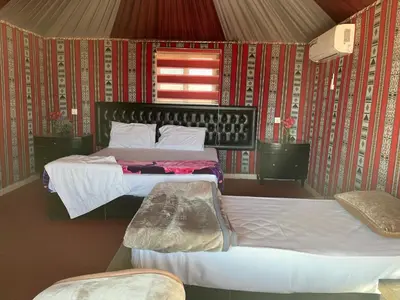 a bedroom with two beds and a window at Rum Rosella camp in Wadi Rum