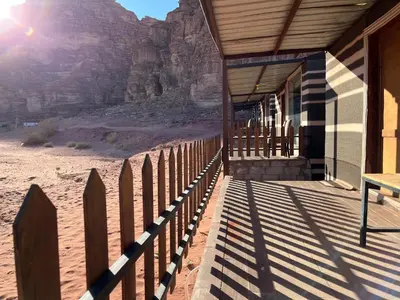 a porch of a building with a fence in the desert at Rum Rosella camp in Wadi Rum
