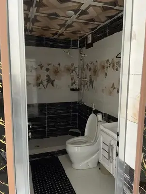 a small bathroom with a toilet and a shower at Rum Rosella camp in Wadi Rum