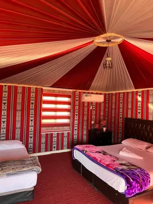 a bedroom with two beds and a ceiling at Rum Rosella camp in Wadi Rum