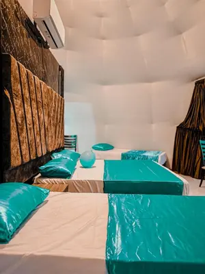 three beds in a room with green pillows at Rum Ronaldo camp in Wadi Rum