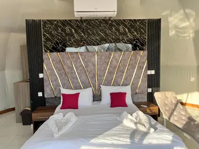 a bedroom with a bed with red pillows at Rum Ronaldo camp in Wadi Rum